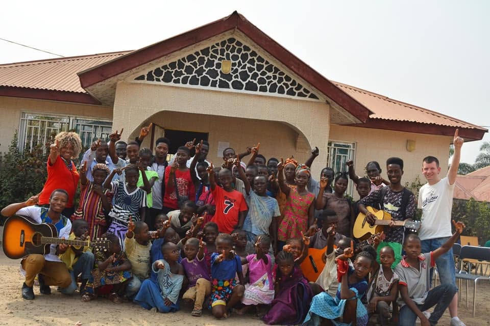 Children and adults gathered outside a community building