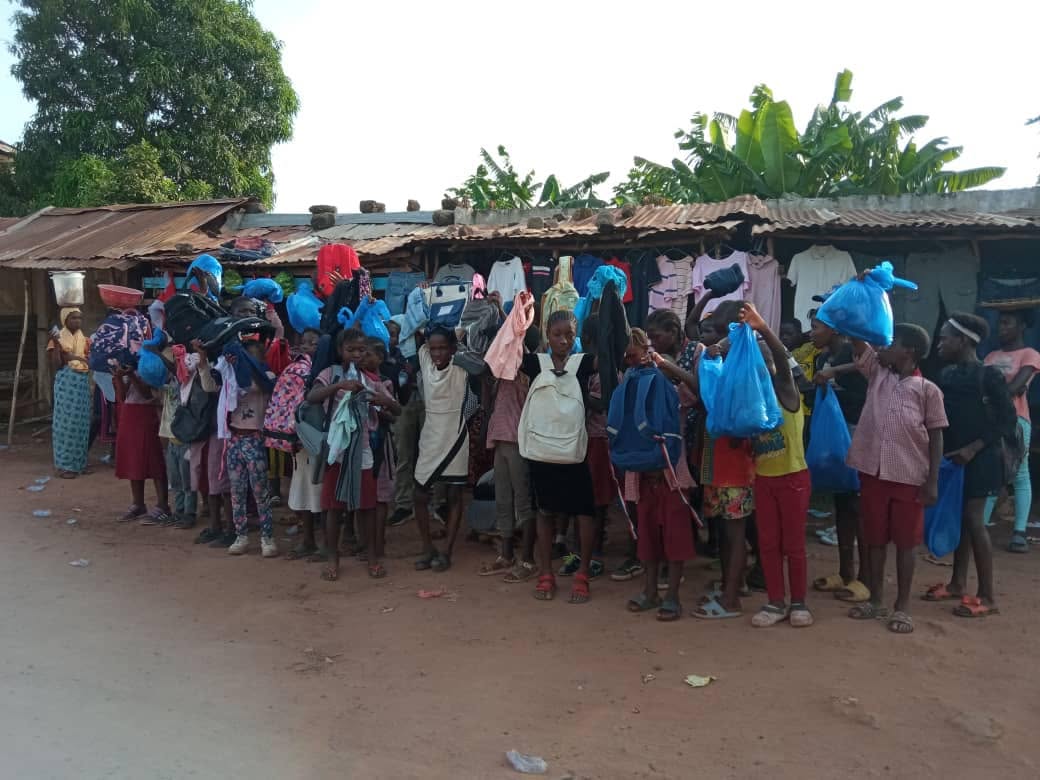 A large group of children and adults gathered outdoors