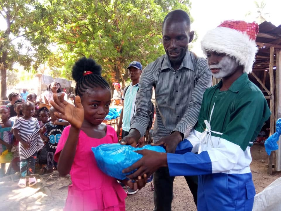 A child receiving a wrapped item from community volunteers