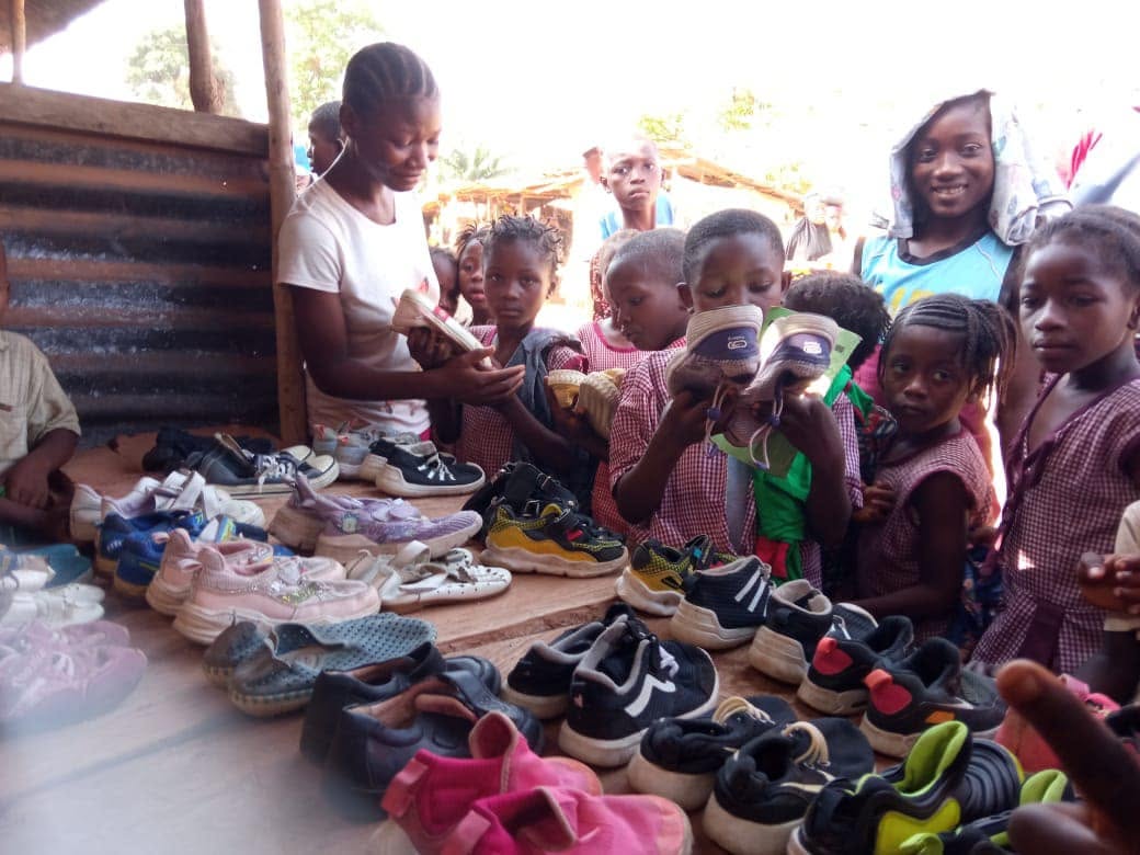 Children gathered around a display of shoes